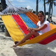 Summer hammock with wooden sticks for sunbathing and cozy hours.